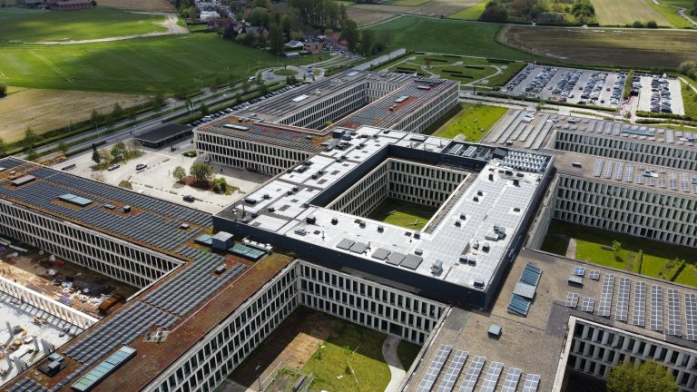Aerial view of an hospital featuring solar panels on its roof, showcasing sustainable energy solutions