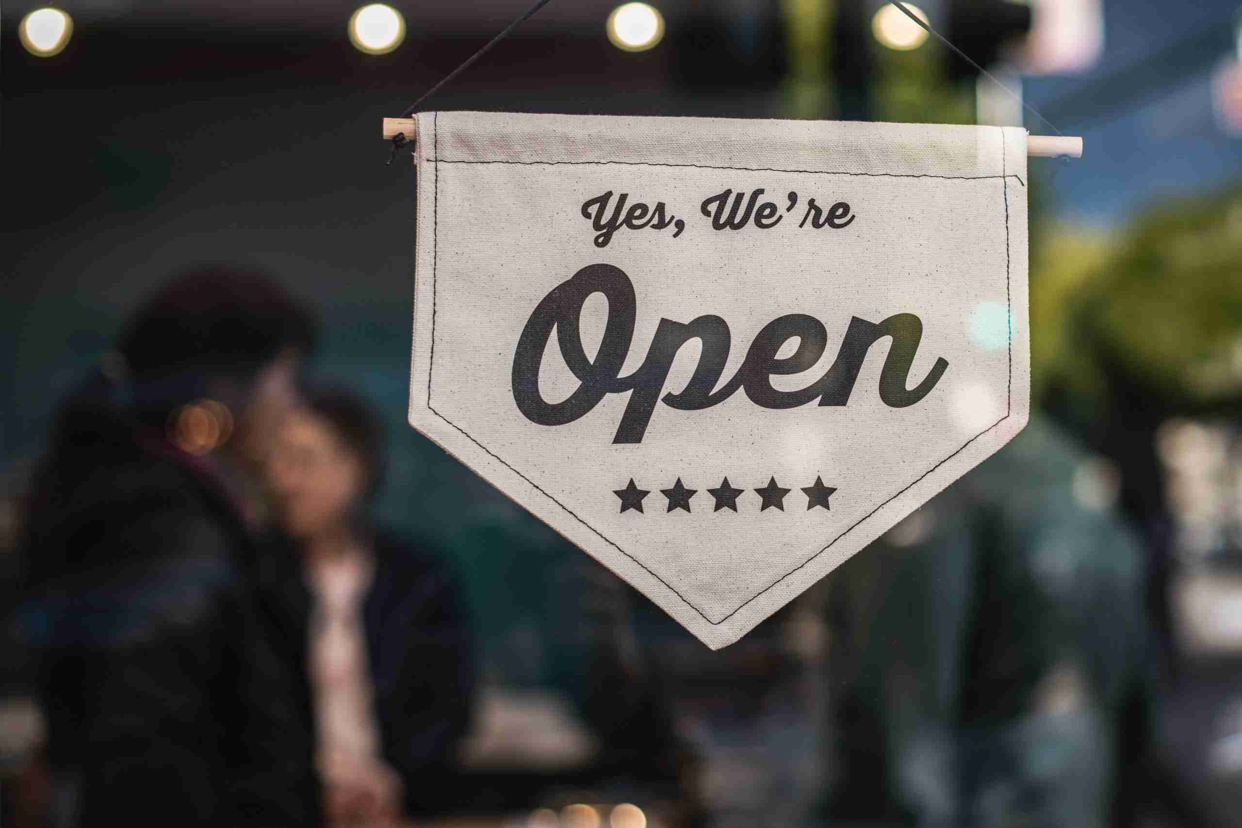A bright "Open" sign displayed in a shop window, inviting customers to enter and explore the store's offerings.